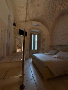 a bedroom with a bed in a stone room at Il Balcone di Anna - Luxury Homes in Ceglie Messapica +8 photos