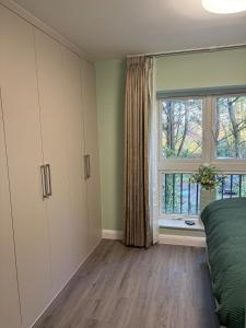 a bedroom with a bed and a window at Petite Apartment in Denham in Denham