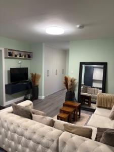 a living room with a couch and a television at Petite Apartment in Denham in Denham