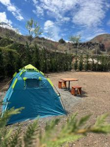 a tent and a picnic table in a field at Camping Koman in Koman