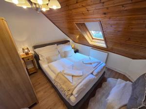 a bedroom with a large bed with a wooden ceiling at Erelia Cottage in Bük