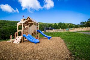 a playground with a slide and a play structure at Huttopia Berkshires in Hancock