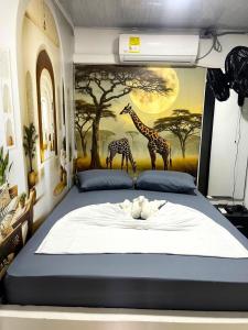 a bedroom with a bed with giraffes on the wall at Sabana Africana in Puerto Triunfo