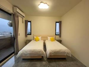 a bedroom with two beds with yellow pillows at 上好所在民宿 in Shoufeng