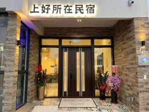 a entrance to a building with a door and flowers at 上好所在民宿 in Shoufeng