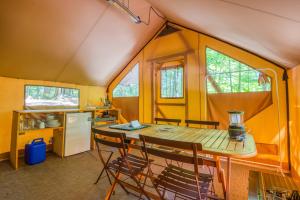 a dining room with a table and chairs in a tiny house at Huttopia Berkshires in Hancock