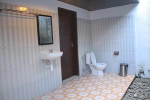 a bathroom with a toilet and a sink at Selong Holiday in Selong Belanak