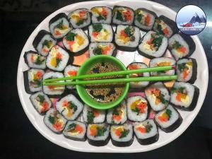 a plate of sushi with green chopsticks on a plate at Laskus Homestay in Darjeeling