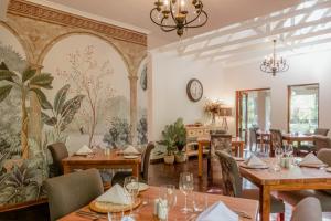 a restaurant with tables and chairs and a clock on the wall at Tuli House in Harare