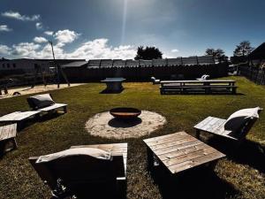 a park with benches and a fire pit in the grass at Martinette in Saint-Pair-sur-Mer