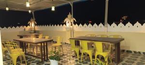 a restaurant with two tables and yellow chairs at Shree ji palace hotel in Udaipur