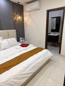 a bedroom with a large bed and a sink at Royale Rest Suites in Rāmkot +2 photos
