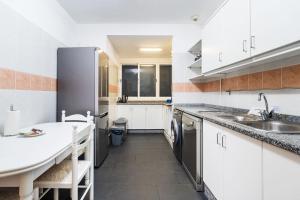 a kitchen with white cabinets and a sink and a counter at GuestReady - Charming Apartment with Ocean Views in Caniço