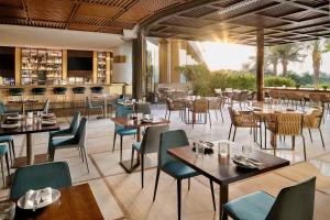 a restaurant with tables and chairs and a bar at JA Lake View Hotel, Dubai in Dubai