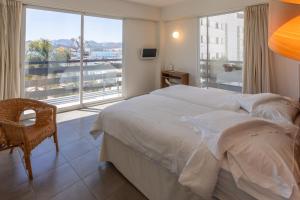 a bedroom with a large bed and a large window at Es Mitjorn Hotel in San Antonio +62 photos