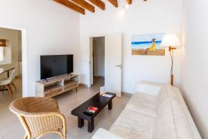 a living room with a couch and a tv at Es Mitjorn Hotel in San Antonio