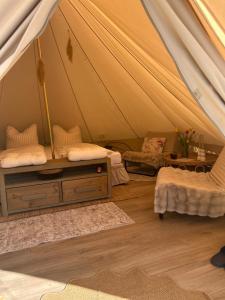 a room with a tent with two beds and a table at Glamping auf dem Weberhof in Münster