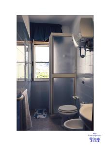 a bathroom with a toilet and a sink and a window at B&B Corte degli Ulivi in Mattinata