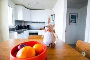 a stuffed animal sitting on a table next to a bowl of fruit at La Loge de la Tour in Calais