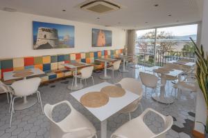 a restaurant with tables and chairs and windows at Es Mitjorn Hotel in San Antonio