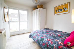 a bedroom with a bed and a large window at La Loge de la Tour in Calais
