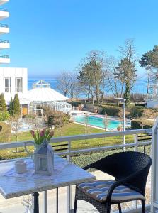 a table and chairs on a balcony with a view of a pool at Haus Anholt in Timmendorfer Strand