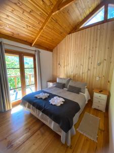 a bedroom with a large bed in a room with wooden walls at Cabañas Parque Almendro in San José de Maipo