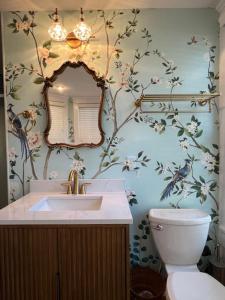 a bathroom with a sink and a mirror and a toilet at Ann Street Inn & Garden in Beaufort