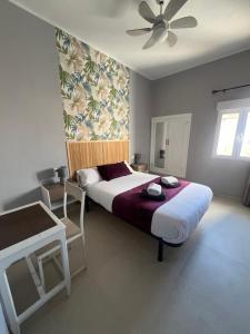 a bedroom with a large bed and a ceiling fan at Almendra B Vitalba Apartments in Lanjarón