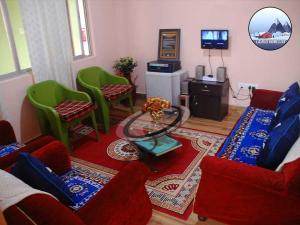 a living room with red furniture and green chairs at Laskus Homestay in Darjeeling
