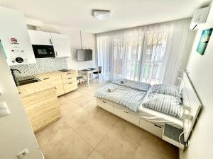 a hospital room with a bed and a kitchen at Ady Corner Prémium Apartmanok - Siófok in Siófok