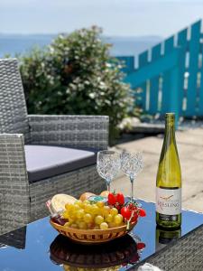 a basket of fruit and a bottle of wine on a table at Arthur's Seat in Innellan