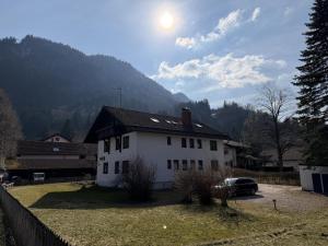 a white house with a car parked in front of it at Alpenblick am Kienberg in Pfronten