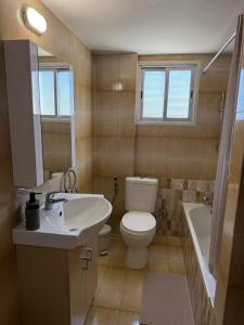 a bathroom with a sink and a toilet and a tub at City Vibes - Central 3BR Spacious Apartment in Larnaca