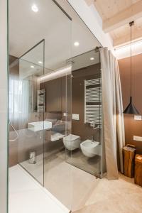 a bathroom with a glass shower and a sink at Margherita Home in Reggio Emilia