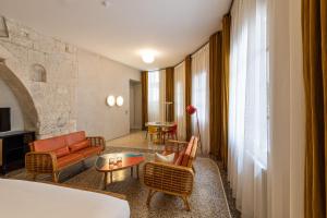 a hotel room with a bed and a living room at Le Cloître in Arles