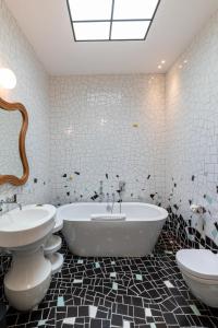 a bathroom with two sinks and a tub and two toilets at Le Cloître in Arles +39 photos
