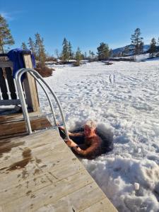 a man is laying in the snow next to a boardwalk at Chalet Vradal in Vradal