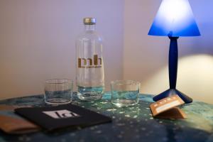 a table with a bottle and glasses and a lamp at Margherita Home in Reggio Emilia +22 photos