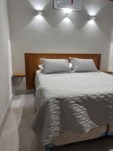 a bedroom with a large bed with two pillows at Chalé Estalagem Sítio Sossego in Domingos Martins