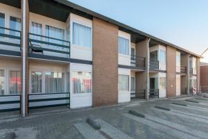 an empty parking lot in front of a building at Welcome in - Appartement aan de duinen met balkon I Duinweg 18, Zoutelande 'Duinroos' in Zoutelande