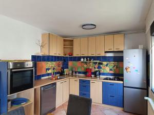 a kitchen with blue cabinets and a refrigerator at Apartman Novak in Samobor