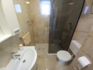 a bathroom with a toilet and a sink and a shower at Vila Neve 87 Apartman in Veliko Brdo +25 photos