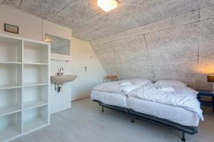 a bedroom with a bed and a sink in it at Welcome in - Appartement met balkon in Veere I Kievitenlaan 22 in Veere