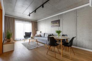 a living room with a couch and a table and chairs at River Side Apartments in Oświęcim