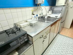 a small kitchen with a sink and a stove at Okayama Urban Peach in Okayama