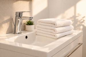 a pile of towels sitting on a bathroom sink at Immeuble privatif 3 logements et 1 logement non loin de l'immeuble in Le Portel +63 photos
