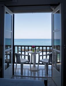 a table and chairs on a balcony with the ocean at Remezzo Guesthouse in Agios Ioannis Pelio +7 photos