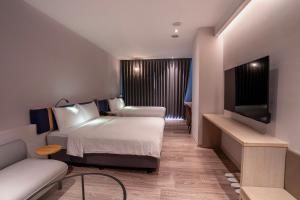 a hotel room with a bed and a flat screen tv at Explore Hotel in Taichung
