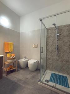a bathroom with a shower and a toilet and a sink at Casa della Cittadella in Noto